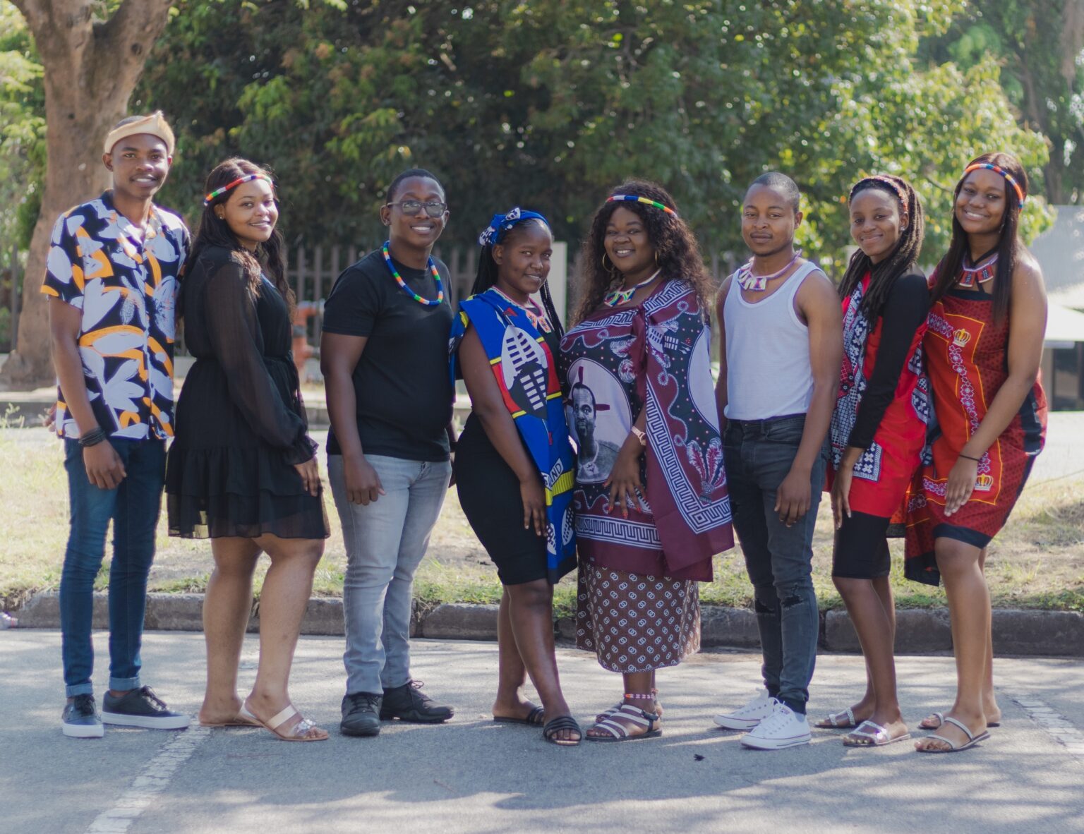 Young people standing together outdoors in colourful Southern African cultural attire